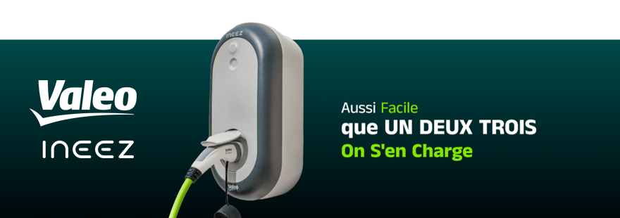 Un chargeur pour véhicule électrique de la gamme INEEZ de Valeo, branché à une prise murale avec un câble vert.